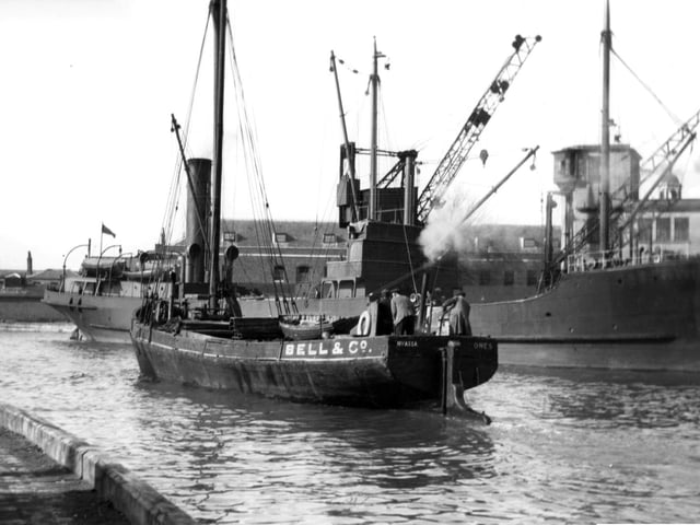 A collier tied up alongside the Camber dock, a long gone scene at the Camber, Old Portsmouth now. We can also see Nyassa the Bell & Co steam vessel registered in Cowes making her way out to the harbour. Picture: Barry Cox collection
