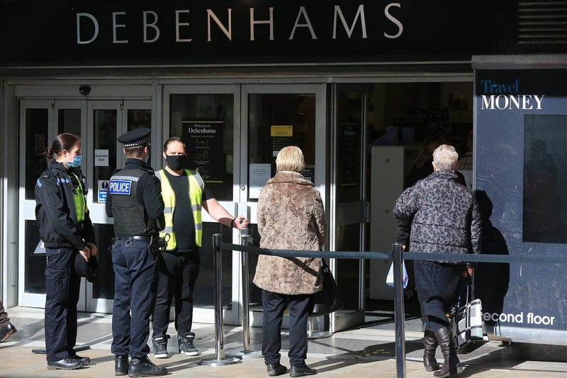 Excited shoppers waiting patiently outside Debenhams before it opens.