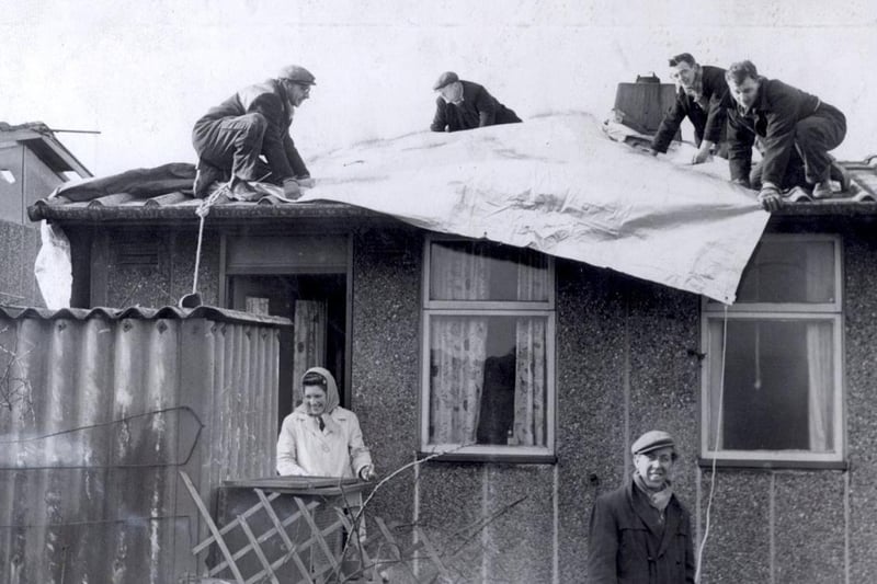 Friday February 16 1962 was one of the darkest days in Sheffield’s history as a hurricane battered the city. The storm left four dead and more than 250 injured with around 70,000 Sheffield homes damaged. Winds of 96mph ripped through the city and hundreds were left homeless. This picture shows residents of Skye Edge Avenue getting a roof over their heads as workmen lay tarpaulin to protect their hurricane ravaged homes the day after the storm.