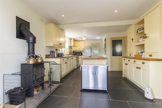 The kitchen has a range of Shaker style wall, drawer and base units with solid wood work surfaces and upstands, including an island unit. The range cooker is included in the sale. There is also a multi-fuel stove and built-in understair store.