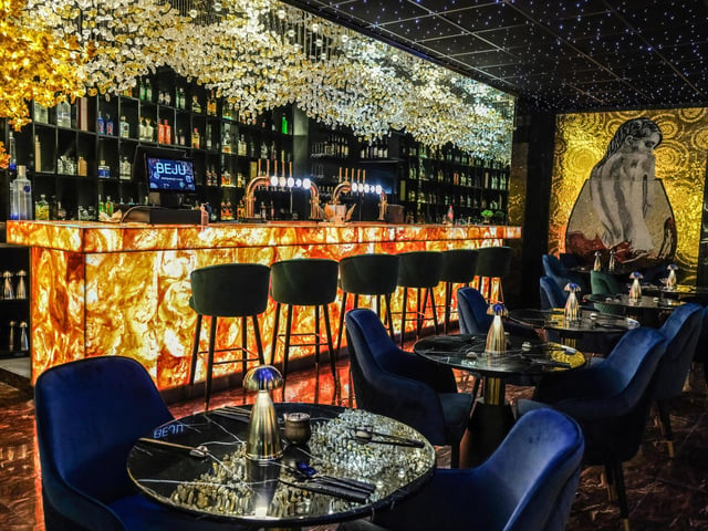 The central bar has a plush seating area where customers can sit and sip drinks.