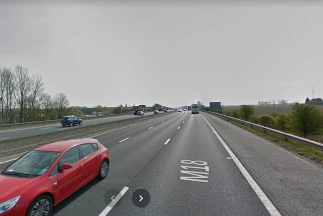 A woman was struck by a lorry on the M18 in South Yorkshire after she fell from a bridge