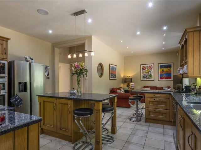 The modern kitchen has a comprehensive range of matching cabinets complemented by granite worksurfaces, central island, shelved larder, and integrated appliances, while the open plan family room is great for casual dining.