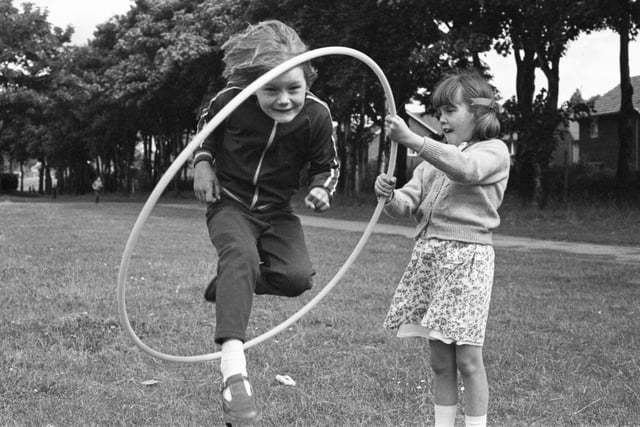 Six-year old Joanne Whiting leaps through the hoop with Lynn Coundon (8) holding on tight at the King George V playing fields play scheme 42 years ago.