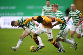 Devante Cole is challenged by Jonjoe Kenny and Stephen Welsh of Celtic.
