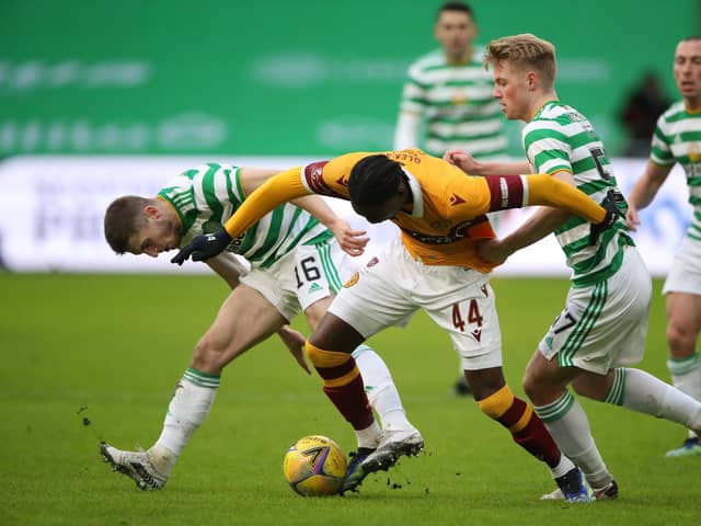 Devante Cole is challenged by Jonjoe Kenny and Stephen Welsh of Celtic.