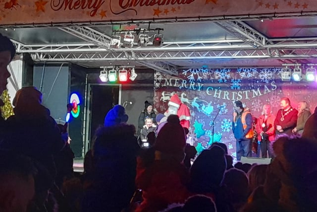 The big man Santa turning on the Christmas lights with the help of young Willow.