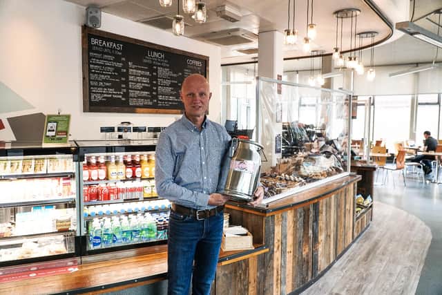 Milk churns help University cafes reduce plastic waste. Pictured is Peter Anstess, Head of Retail at the University.
