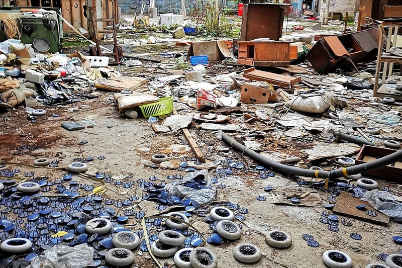 A large number of wheels are among the items dumped on the floor of the old building.