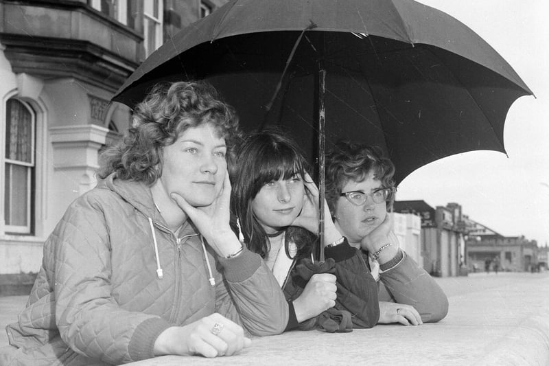 Visitors take shelter under an umbrella during a typical summer day at Portobello in 1965.