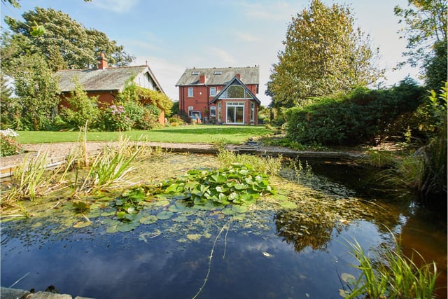 The property boasts landscaped gardens to the rear, including a pond.
