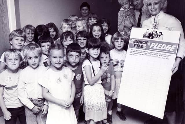 Children line up to sign a "Don't talk to a stranger" pledge held by Janet Dunkley in her role as Auntie Janet of the Junior Star, in October 1985
