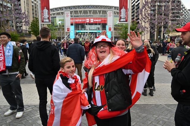 Fans arrive ahead of the English FA Cup semi-final football match between Manchester City and Sheffield United at Wembley Stadium in north west London on April 22, 2023.
