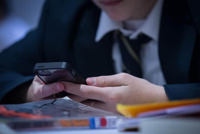 A pupil uses his mobile phone (Photo by Matt Cardy/Getty Images)