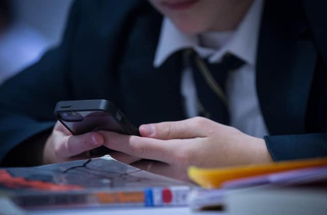 A pupil uses his mobile phone (Photo by Matt Cardy/Getty Images)