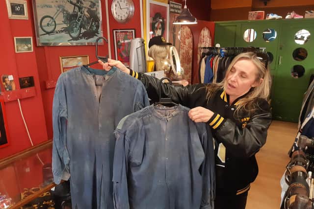 Freshmans vintage store owner Louisa Froggatt with two French smocks, which are the oldest garments in the shop