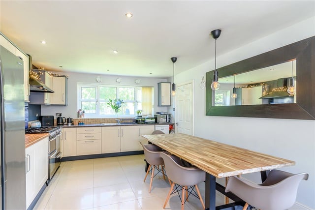 The stylish kitchen dining room is contemporary in style, with integrated appliances, plenty of room for family meals, and views overlooking the garden.