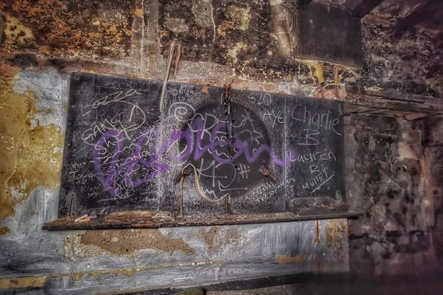 The area around the old darts board is covered with graffiti (pic: Laura Rickers/Abandoned Memoriez Urbex)