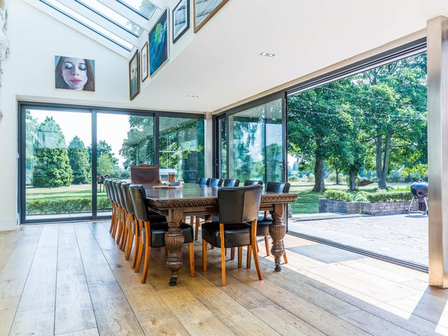 The full length sliding doors make the most of the two acre mature grounds the house sits in.