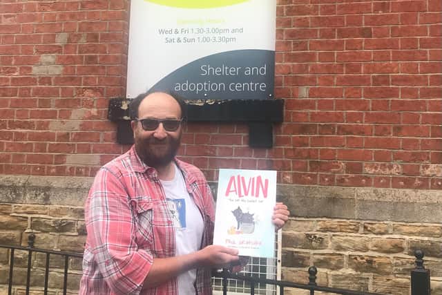Paul Grimshaw with his book outside The Sheffield Cats Shelter.