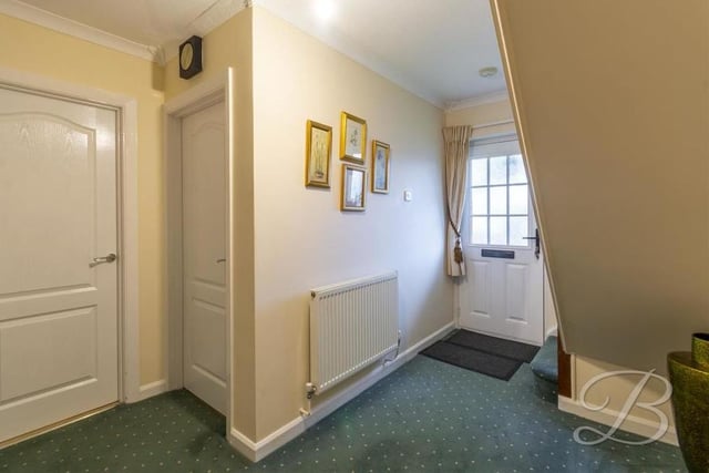 This is the entrance hallway to the bungalow. It has a carpeted floor, central-heating radiator and access to the kitchen and living room.