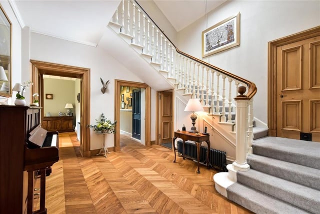 The reception hall is one of the loveliest rooms in the house with the oak chevron floor highlighting the elegant timber stair rail and panelled doors.