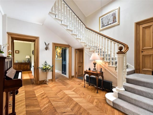 The reception hall is one of the loveliest rooms in the house with the oak chevron floor highlighting the elegant timber stair rail and panelled doors.