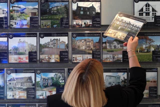 A woman looking at houses for sale in an estate agents as borrowers rushed to take advantage of the stamp duty holiday