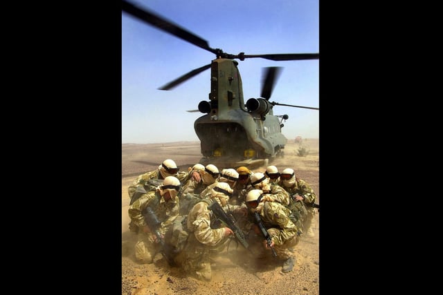 Landing Zone
Commandos shield themselves from the down blast of an RAF Chinook helicopter which has just dropped them in the desert at the start of a patrol during a training exercise in Oman 2003.
Picture: PO[Phot] Steve Lewis