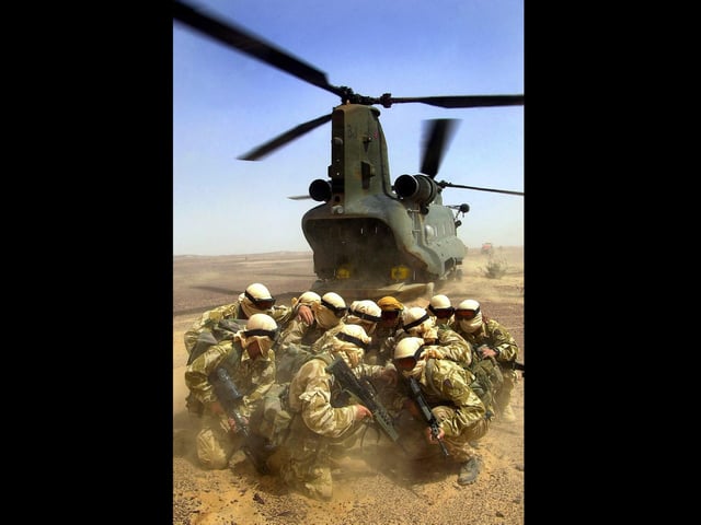Landing Zone
Commandos shield themselves from the down blast of an RAF Chinook helicopter which has just dropped them in the desert at the start of a patrol during a training exercise in Oman 2003.
Picture: PO[Phot] Steve Lewis