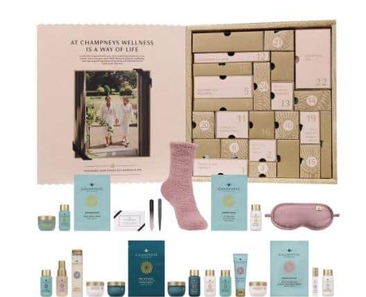 Champneys 24 Days of Spa Glow Advent Calendar contains body cleansers and lotions, bath milk and salts, an eye mask and fluffy socks.