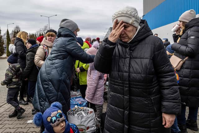 Ukrainian refugees stand outside a Temporary Reception Centre in Korczowa, on March 02, 2022. - The number of refugees fleeing the conflict in Ukraine has surged to nearly 875,000, UN figures showed on on March 2, as fighting intensified on day seven of Russia's invasion. (Photo by Wojtek RADWANSKI / AFP) (Photo by WOJTEK RADWANSKI/AFP via Getty Images)