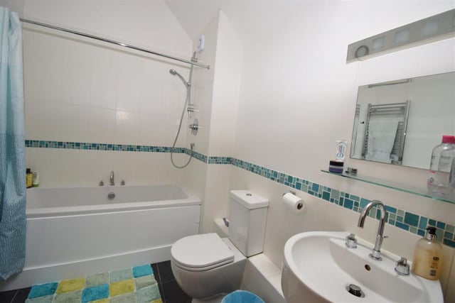 The family bathroom has plenty going for it. It is fitted with a white suite, comprising a bath with shower over, a low-flush WC, wash hand basin, tiled floor, built-in cupboard and Velux window.