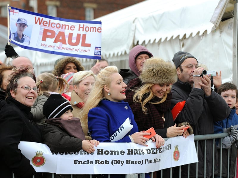 12th December 2014. HMS Defender returned home into Portsmouth on Friday after more than six months away deployed on high intensity operations in the Northern Gulf.
Pictured is: Family and friends wave to their loved ones on board HMS Defender, as they arrive home into Portsmouth.
Picture: Sarah Standing (143541-8670)