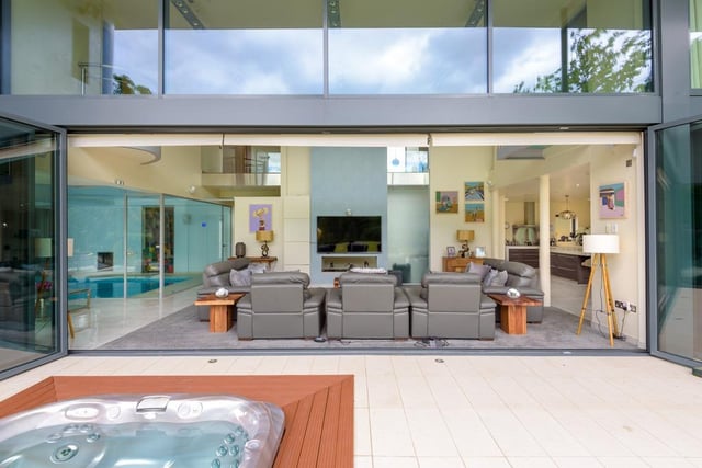 The rear of the property is covered with floor-to-ceiling windows and bi-folding doors.