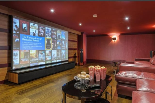 Sit back and enjoy a film in the home cinema. It features panelled walls, projector screen and leather furniture. Image by Rightmove.