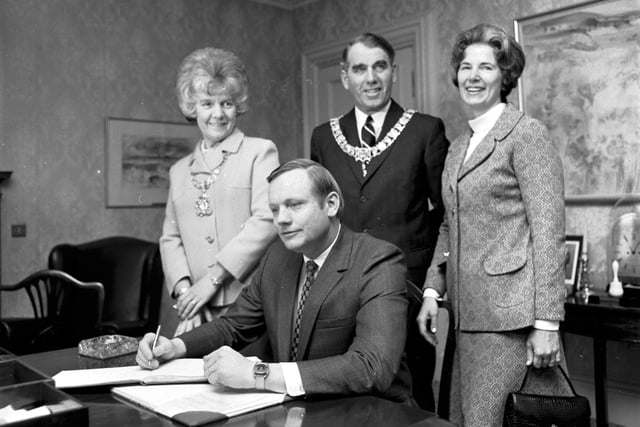 American astronaut Neil Armstrong signs the visitors' book at Edinburgh City Chambers in March 1972, watched by Lord Provost James McKay and his wife.