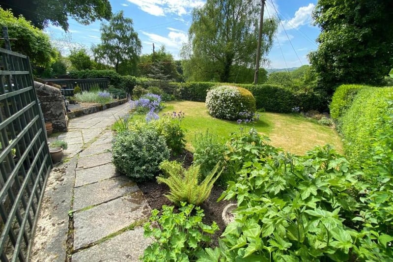 The lawn garden has a central ornamental hedge, a mature hedgerow and a range of mature trees and plants around the perimeter.