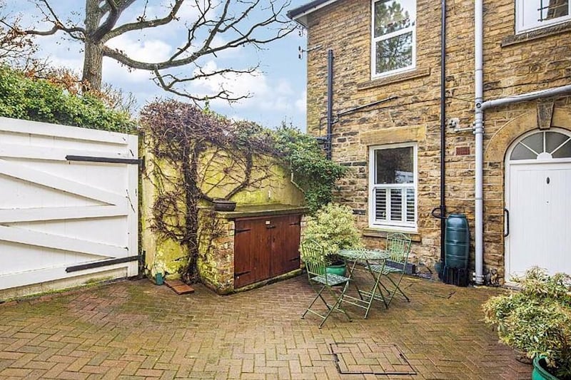 The property is accessed via gates and through a small courtyard to a private entrance.
