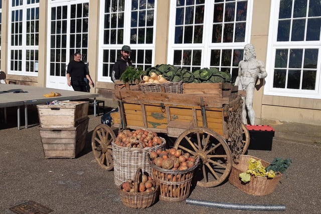A cart full of cabbages and baskets of turnips on the set.