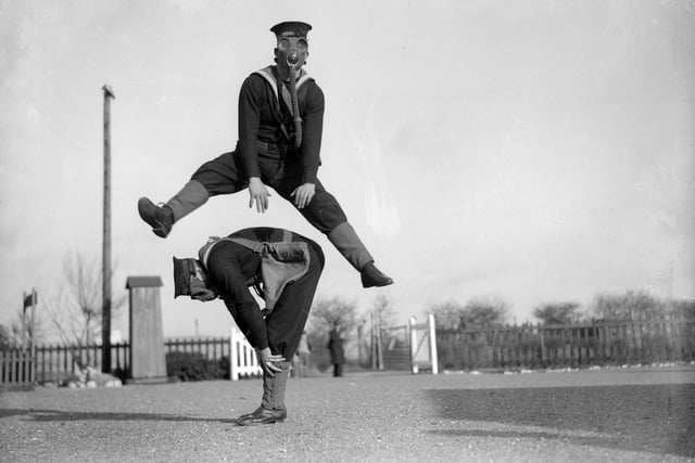 22nd January 1934:  Able seamen at the Royal Navy Anti-Gas School at Tipnor, Portsmouth play leapfrog wearing gas masks, to accustom them to carrying out strenuous tasks in respirators.  (Photo by William Vanderson/Fox Photos/Getty Images)