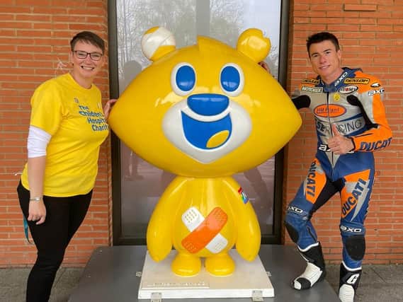 Two-time World Superbike Champion and patron of The Children’s Hospital Charity, James Toseland (left) posing with a volunteer and Theo Bear.