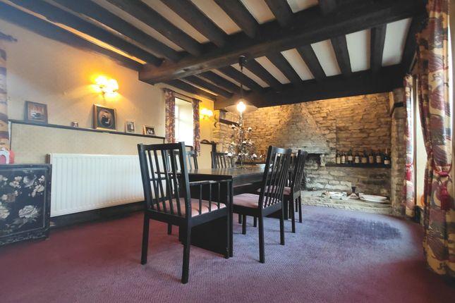 This traditional room boasts exposed beams and is currently used as a dining room.