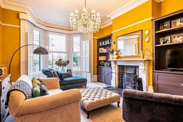 The house features two spacious formal reception rooms - this is the lounge, which has an impressive bay window with shutters and a large fireplace.