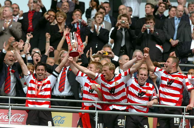 Rovers skipper Brian Stock lifts the trophy and leads the celebrations after victory in the play-off final at Wembley