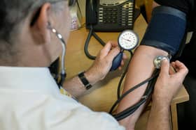 File photo of a doctor checking a patient's blood pressure. PRESS ASSOCIATION Photo