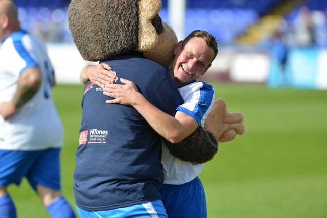 A player celebrates with Hartlepool United mascot H'Angus the Monkey during a fundraising match orgnanised by town charity Miles for Men.