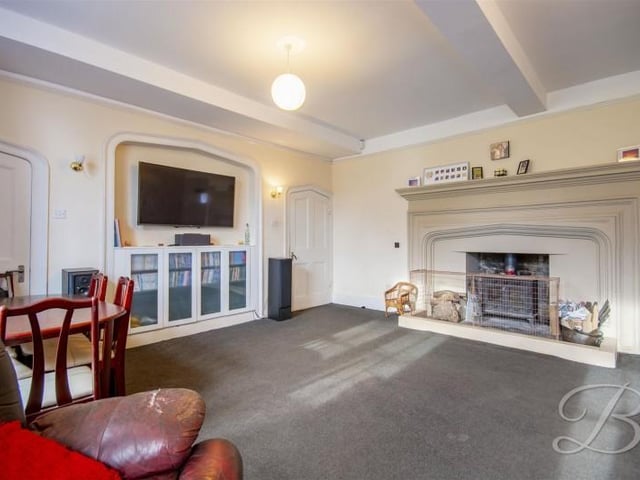 The second living room has two windows and a huge fireplace surround.