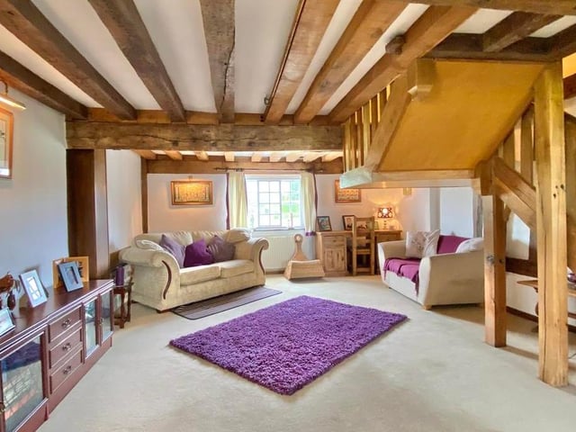 Another view of the comfortable lounge, beams and all. To the right is a solid oak staircase that rises to the west wing bedroom and shower.