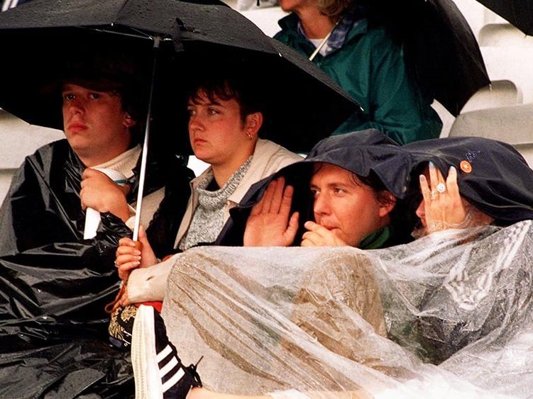 Fans shelter from the pouring rain during the Paul Weller concert at Don Valley Stadium, Sheffield, in July 1997
